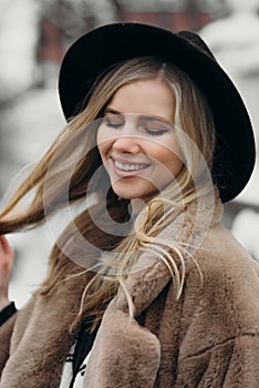 Smiling young woman hat coat outside flowers bouquet yellow joy gift blonde model