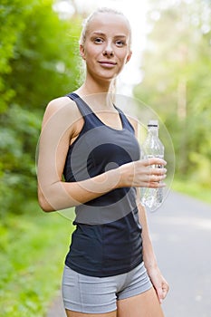 Smiling young woman having her break after running