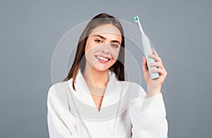 Smiling young woman with healthy teeth holding a tooth brush. Human teeth. Dental health care clinic. Close-up of a