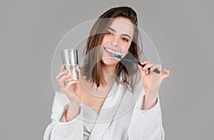 Smiling young woman with healthy teeth holding a tooth brush. Human teeth. Dental health care clinic. Close-up of a