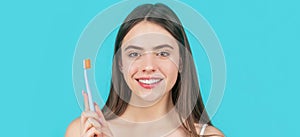 Smiling young woman with healthy teeth holding a tooth brush. Young beautiful girl holding a toothbrush. Happy girl