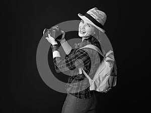 Smiling young woman hiker with modern DSLR camera taking photo