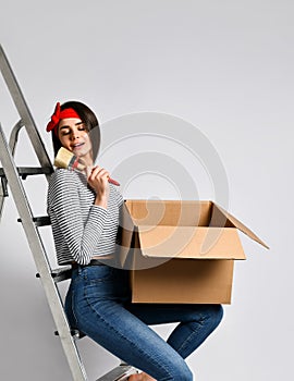Smiling young woman holding cardboard box isolated on white background