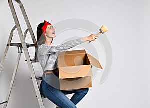 Smiling young woman holding cardboard box isolated on white background