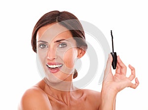 Smiling young woman holding eyelash brush