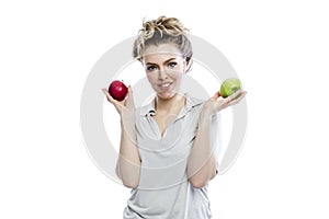 Smiling young woman holding green and red apples in her hands. Beautiful blonde in a gray polo. Healthy food, vegetarianism and