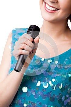 Smiling young woman holding microphone, close up