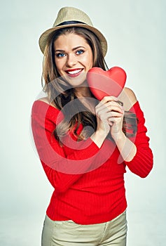 Smiling young woman holding symbol of love