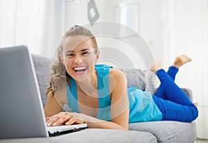 Giovane donna dire bugie sul divano un computer portatile 