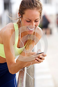 Smiling young woman listening to music with MP3 player