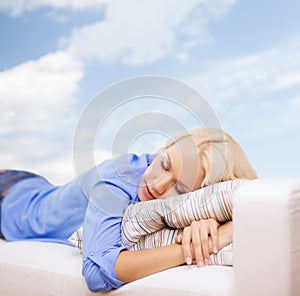 Smiling young woman lying on sofa