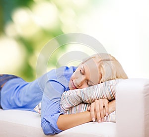 Smiling young woman lying on sofa