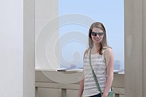 Smiling young woman outdoors with green purse