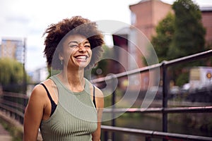 Smiling Young Woman Outdoors Laughing As She Walks Through City