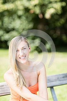 Smiling young woman on a park bench
