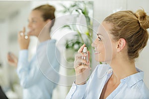 smiling young woman with perfum bottle