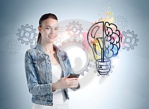 Smiling young woman with phone in hands, gears and light bulb