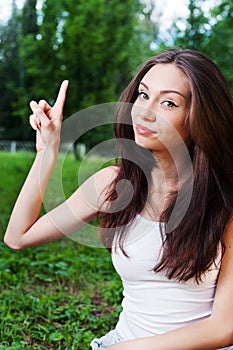 Smiling young woman pointing with her finger