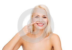 Smiling young woman pointing to her nose