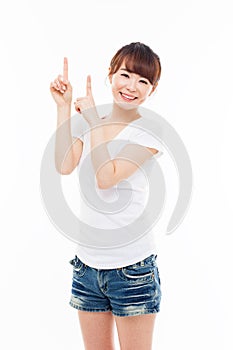 Smiling young woman pointing upwards