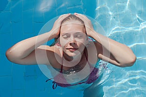 Smiling young woman in the pool with closed eyes. Concept rest,