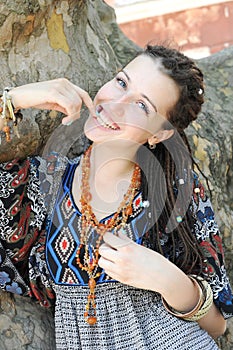 Smiling young woman portrait with dreadlocks hairstyle posing in a sunny outdoor