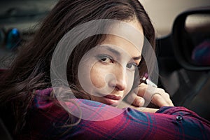 Smiling young woman portrait sit in car leaning on window