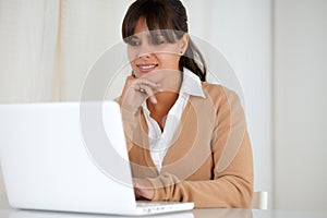 Smiling young woman reading on laptop screen