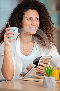 smiling young woman reading newspaper