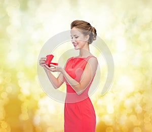 Smiling young woman in red dress with gift box