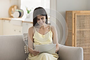 Smiling young woman relax at home use tablet