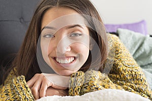 Smiling young woman relaxing at home on sofa