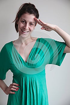 Smiling young woman saluting