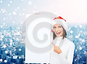 Smiling young woman in santa hat with white board