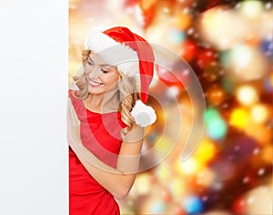 Smiling young woman in santa hat with white board