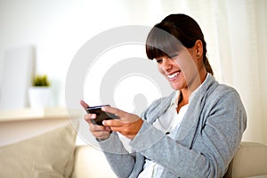 Smiling young woman sending a message by cellphone