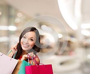 Smiling young woman with shopping bags