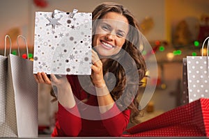 Smiling young woman showing christmas shopping bag