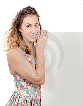 Smiling young woman showing empty blank signboard with copyspace