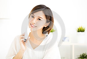 Smiling young woman showing skincare products