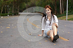 Smiling young woman sitting on asphalt road she`s happy and relax