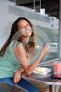 Smiling young woman sitting at outdoor cafe