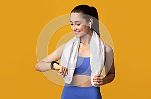 Smiling Young Woman In Sportswear Checking Activity Tracker