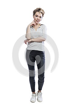Smiling young woman is standing. Beautiful blonde in black leggings, a gray t-shirt and white sneakers. Positivity and happiness.