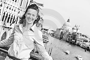 Smiling young woman standing on bridge with grand canal view in