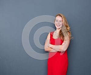 Smiling young woman standing on gray background