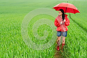 Smiling young woman standing on rainy day