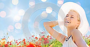 Smiling young woman in straw hat on poppy field