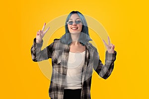 Smiling young woman student with blue hair doing positive gestures