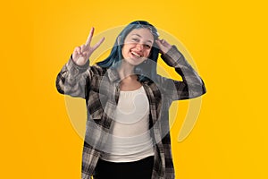 Smiling young woman student with blue hair doing positive gestures